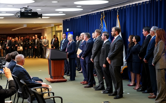 Attorney General Pamela Bondi delivers remarks from a podium at the U.S. Attorney’s Office for the Eastern District of New York. She is joined by federal government officials.
