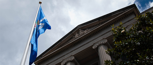 Department of Justice Building with flag and clouds
